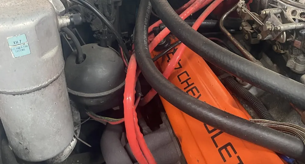 Engine bay with orange Chevrolet valve cover and red ignition wiring