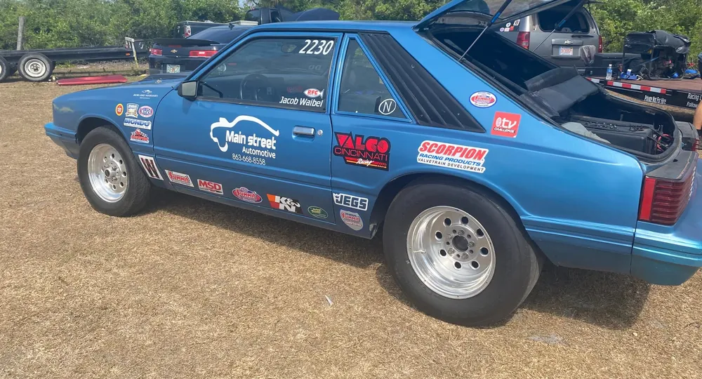 Blue race car with Harrell's Main Street Automotive lettering, hood open