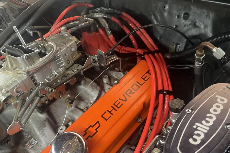 Chevrolet engine with orange valve cover, carburetor and red ignition wires