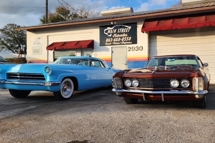 Classic cars parked outside the shop